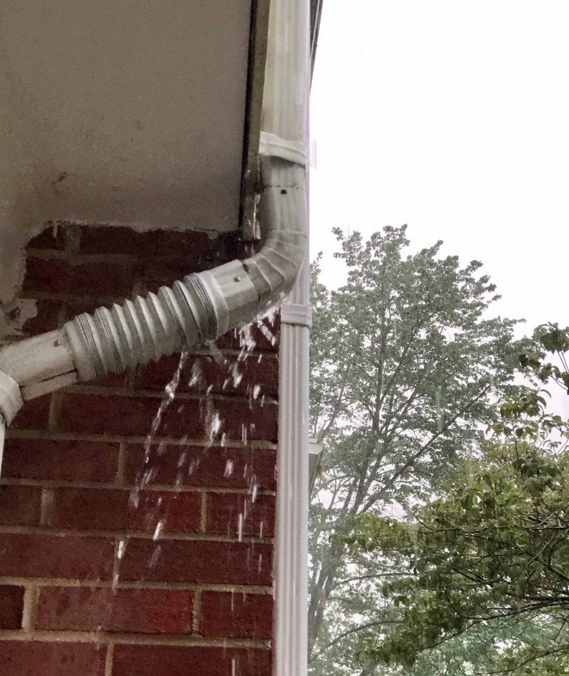 rain overflowing gutters and downspout